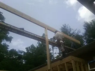 Carpenter setting a ridge beam over a new addition frame — Ice Dam Removal by Roofing Brothers in Dunfermline