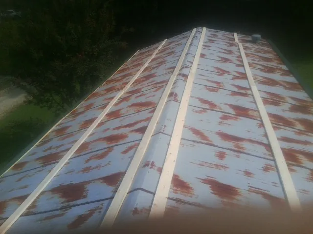 Rusted metal roof panels with new wood purlins before replacement — Storm Damage Roof Repair in Dunfermline by Roofing Brothers