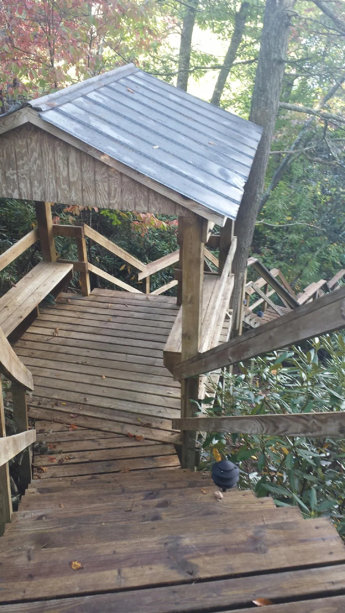 Metal roofed shelter over wooden steps on a wooded walkway — Skylight Repair & Installation work by our crew in Dunfermline